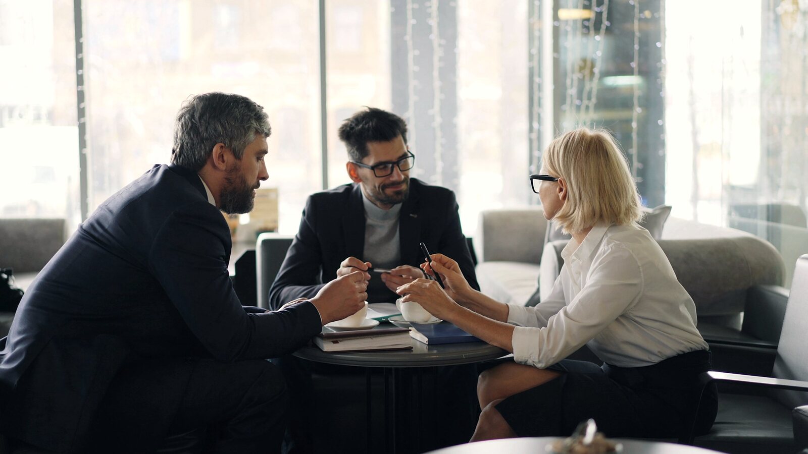 Three advisors in conversation around a table